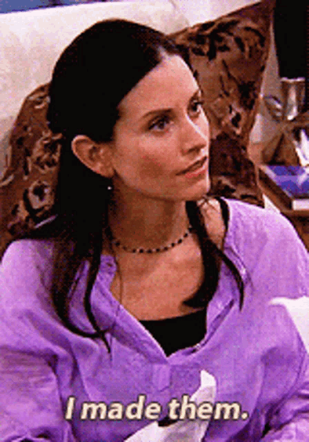 a woman in a purple shirt is sitting on a couch and says i made them