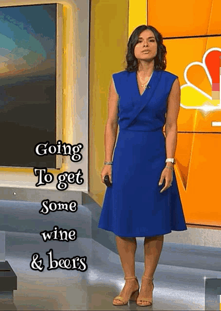 a woman in a blue dress is standing in front of a nbc sign