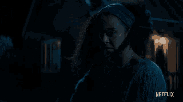 a woman in a blue headband is standing in front of a netflix ad