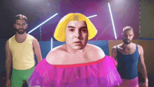 a man with a yellow wig and a pink dress is surrounded by two other men