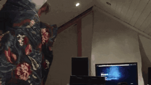 a person wrapped in a blanket is standing in front of a computer screen that says sherlock