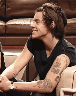 a man wearing a black shirt and a headband is smiling