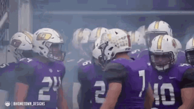 a group of football players wearing purple and white uniforms with the number 24 on the back