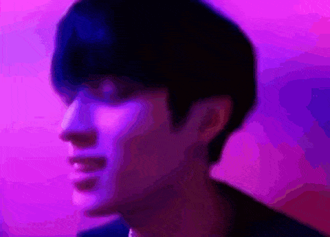 a close up of a man 's face with a purple background .