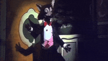 a cartoon cat in a tuxedo and bow tie is dancing in a dark room .