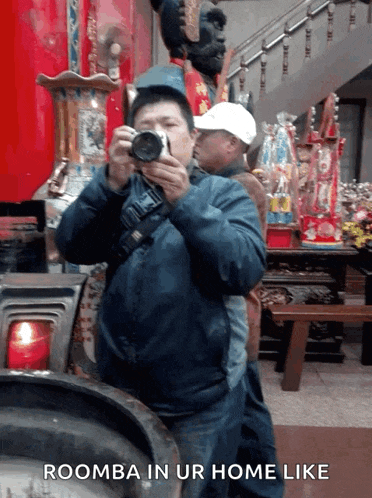 a man taking a picture with a camera with roomba in ur home like written below him