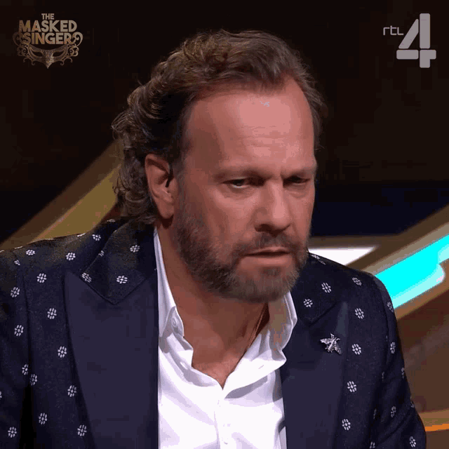 a man with a beard appears on the masked singer