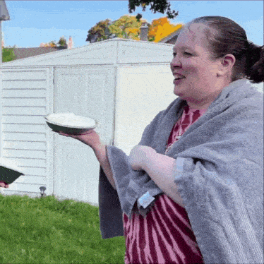 a woman is wrapped in a towel and holding a pie