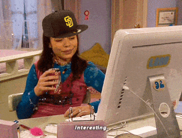 a woman wearing a san diego hat is looking at a computer