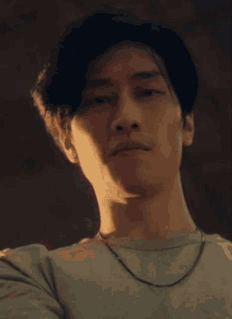 a close up of a man 's face wearing a necklace