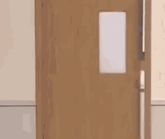 a wooden door with a window is open to a hallway