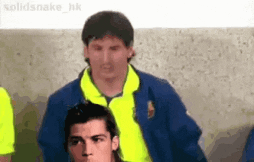 a group of soccer players are standing next to each other and one of them is wearing a yellow shirt .