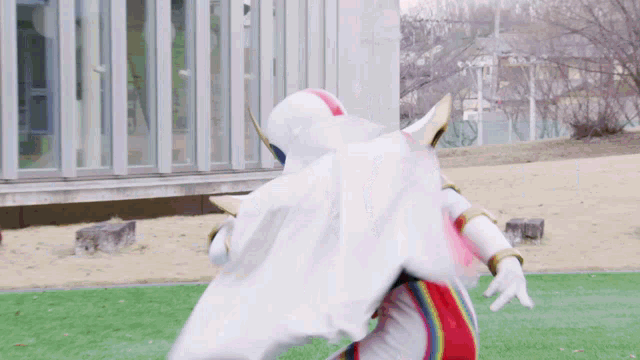 a person in a white cape is standing on a field