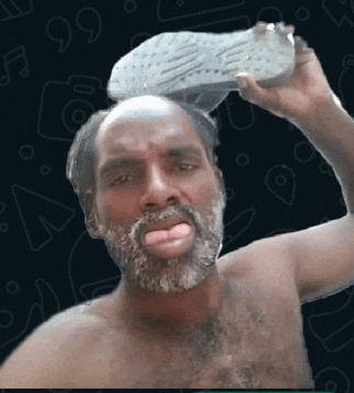 a man without a shirt is holding a shoe on his head