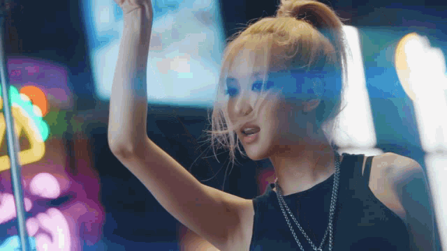 a woman in a black tank top with a ponytail