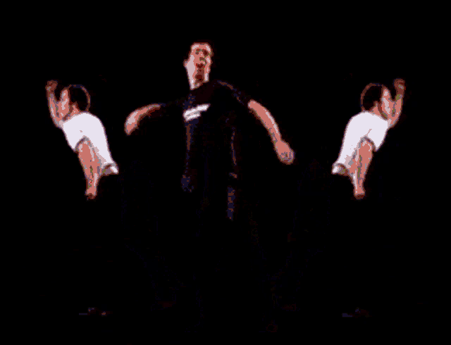 a man in a black shirt is dancing with two other men on a red background