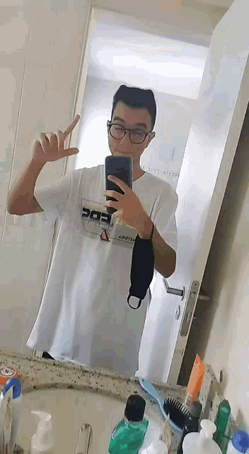 a man taking a selfie in front of a mirror with a shirt that says edc on it