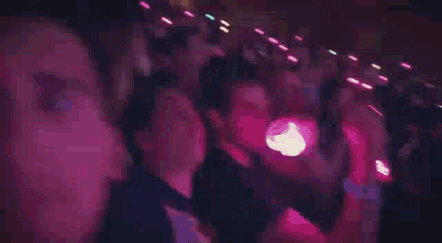 a blurry picture of a person holding a blue object in the dark .