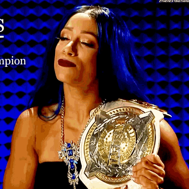 a woman with blue hair is holding a wrestling championship