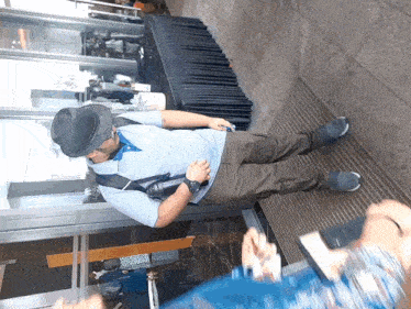 a man wearing a hat is standing in front of a table