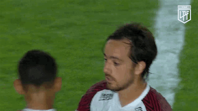 two soccer players are hugging each other on a field .