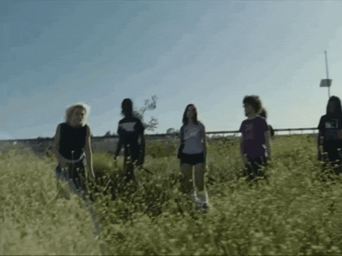 a group of people standing in a field with one wearing a shirt that says ' i love you ' on it