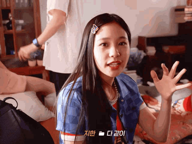 a girl with long hair is wearing a blue shirt with a striped sleeve