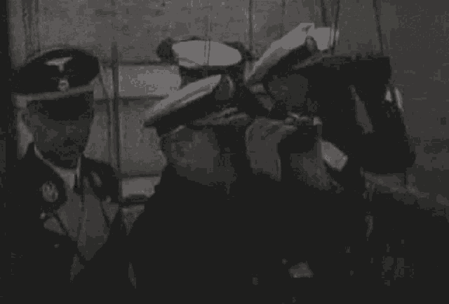 a group of men in uniform are looking through binoculars .