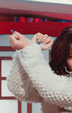 a woman wearing a white sweater and hoop earrings