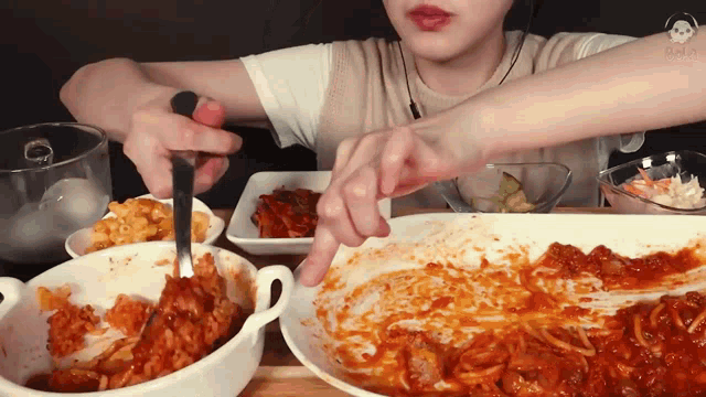 a person is eating a bowl of food with a spoon and fork