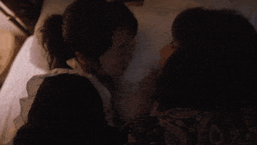 a woman laying on another woman 's back with a lamp in the background
