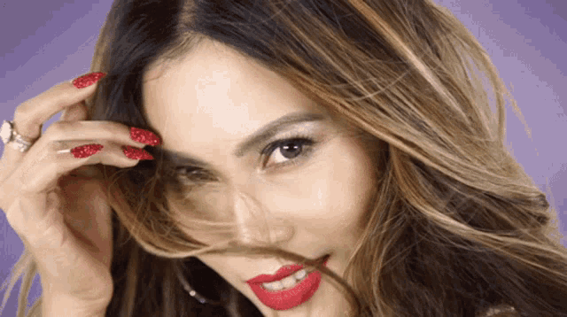 a woman with long red nails and red lipstick