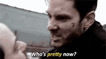 a man is talking to another man and the man is asking who 's pretty now