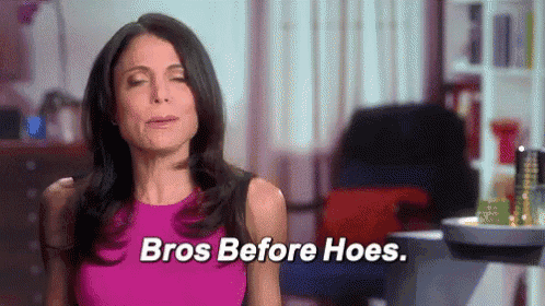 a woman in a pink dress is sitting in a living room with her eyes closed and says `` bros before hoes '' .