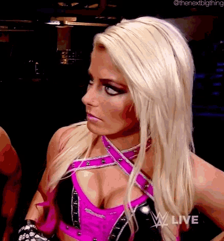 a blonde woman in a pink and black outfit is standing in front of a man .