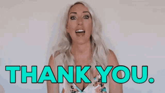a woman is standing in front of a white wall and says `` thank you '' .