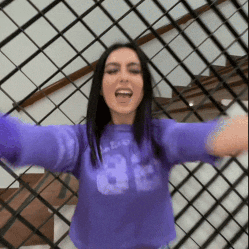 a woman wearing a purple shirt that says ' a ' on it