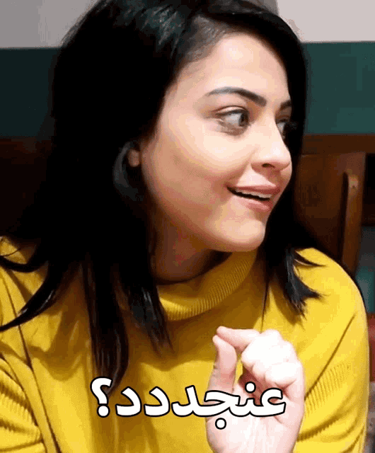 a woman wearing a yellow sweater with arabic writing on the bottom of her face