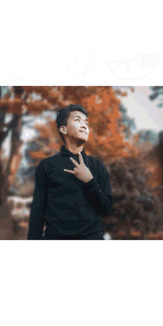 a young man making a peace sign with his hand