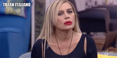 a woman with blonde hair and red lipstick is sitting on a couch with the words trash italiano above her .