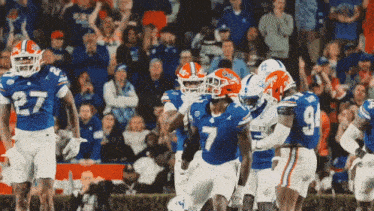 a group of football players wearing florida jerseys and helmets