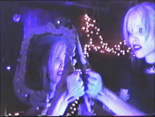 a couple of people standing next to each other in a dark room with purple lights behind them