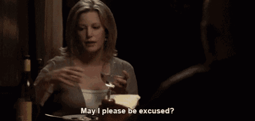 a woman sits at a table with a glass of wine and says may i please be excused ..