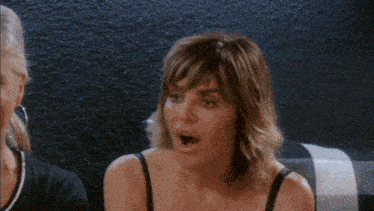 two women are sitting next to each other and one has her mouth open