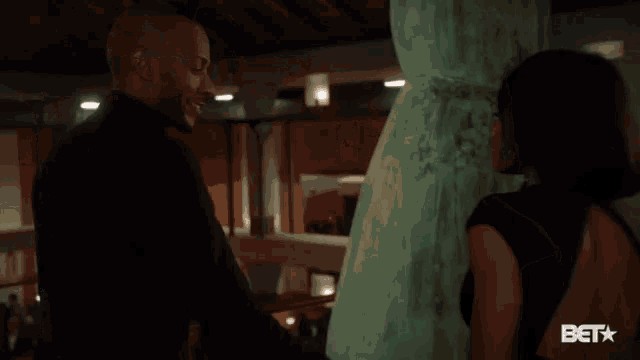a man and a woman are standing next to each other and the woman is wearing a black dress