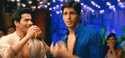 a couple of men are dancing together in a club and holding hands .
