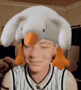 a person wearing a stuffed animal hat with an orange duck on it