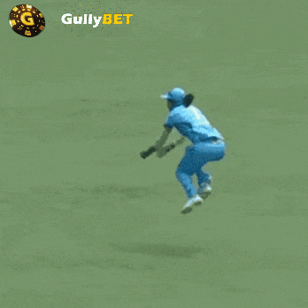 a man in blue pants is kneeling down on a green field with gullybet written on the bottom