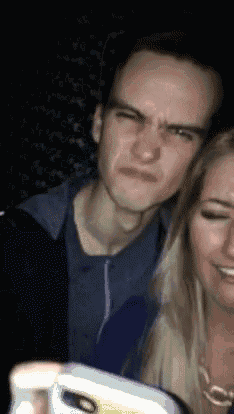 a man and a woman are posing for a picture with a cell phone
