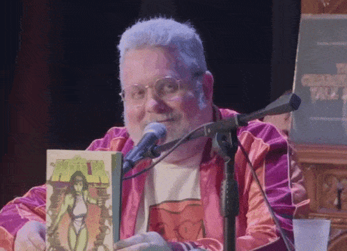 a man is holding a comic book in front of a microphone with a sign that says chicago talk